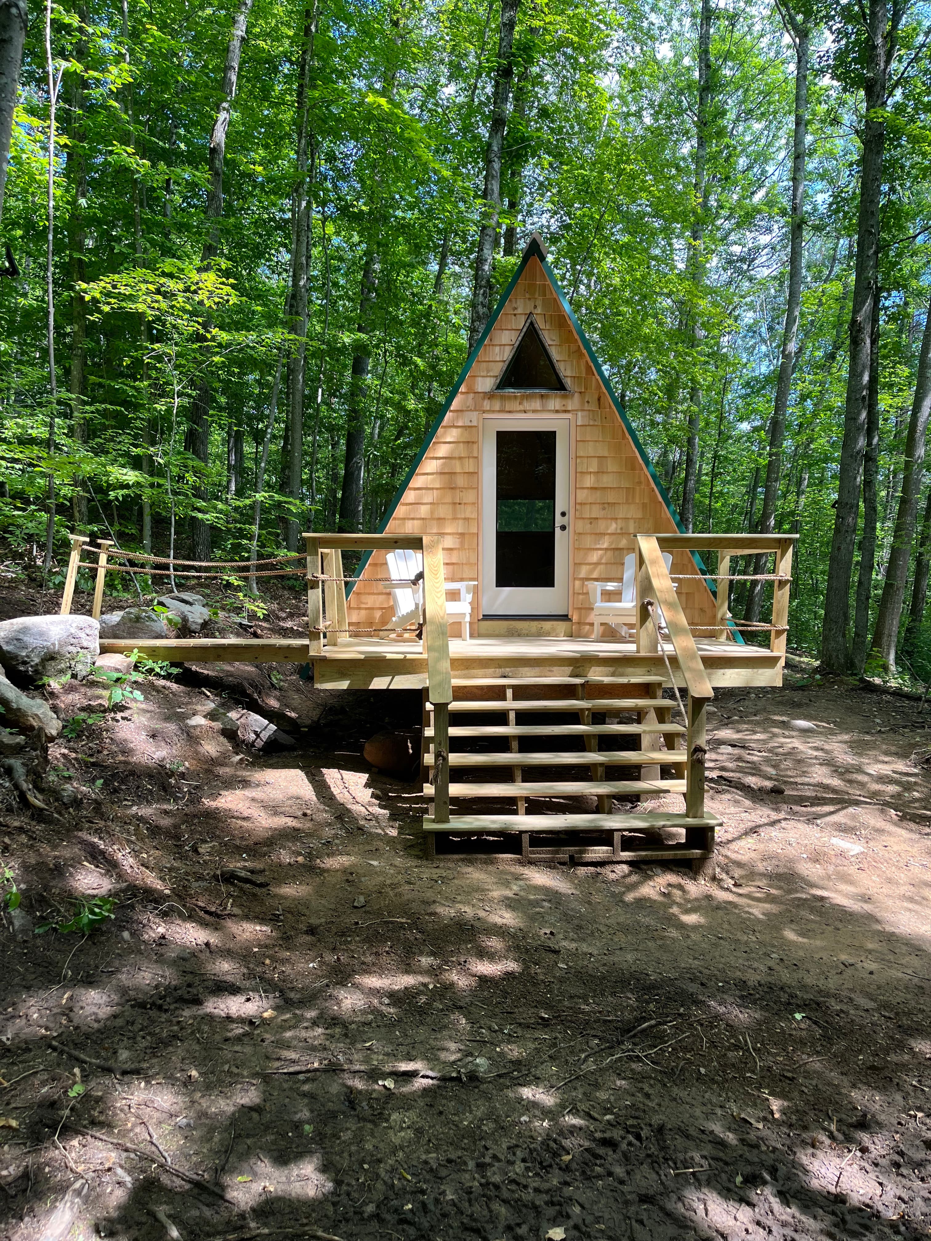 The Bogey A-frame cabin with its deck and steps in the woods